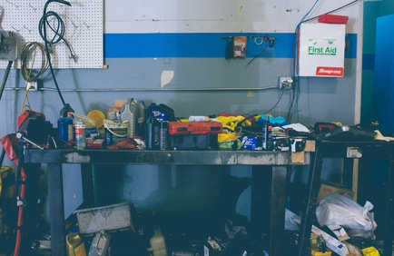 Cluttered garage workbench awaiting garage clearance